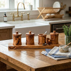 Four olive wood canisters on a long carved base for pantry storage.