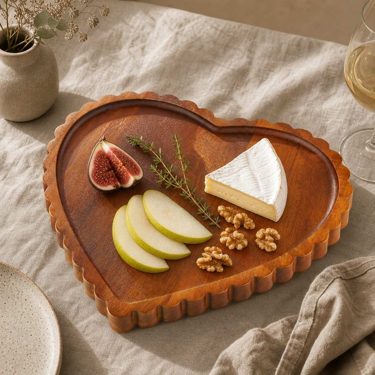 Acacia heart tray set with brie, cured meat, raspberries and cashews on a marble table — Serein Home