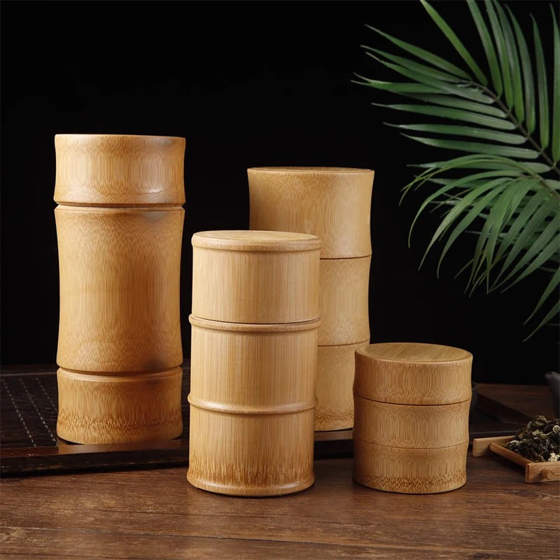 Four bamboo tea canisters in different heights with fitted lids on a dark wood tea table, Serein Home