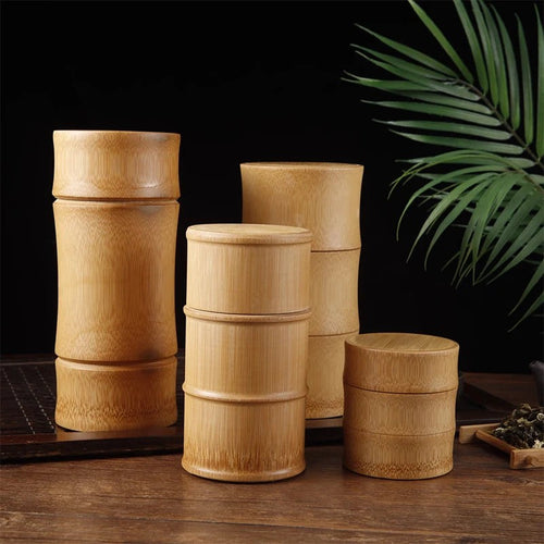 Four bamboo tea canisters in different heights with fitted lids on a dark wood tea table, Serein Home