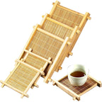 Four square bamboo tea coasters stacked, one holding a small cup of tea, on white, Serein Home