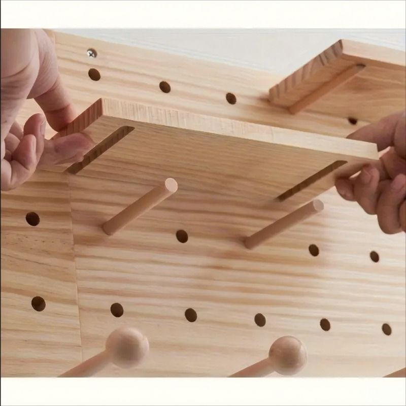 Wooden pegboard with pegs being inserted by hands on a light background