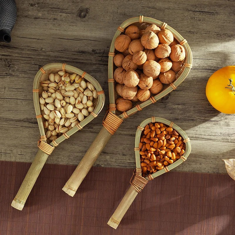 Bamboo strainer scoops holding walnuts, pistachios and almonds beside an orange, Serein Home