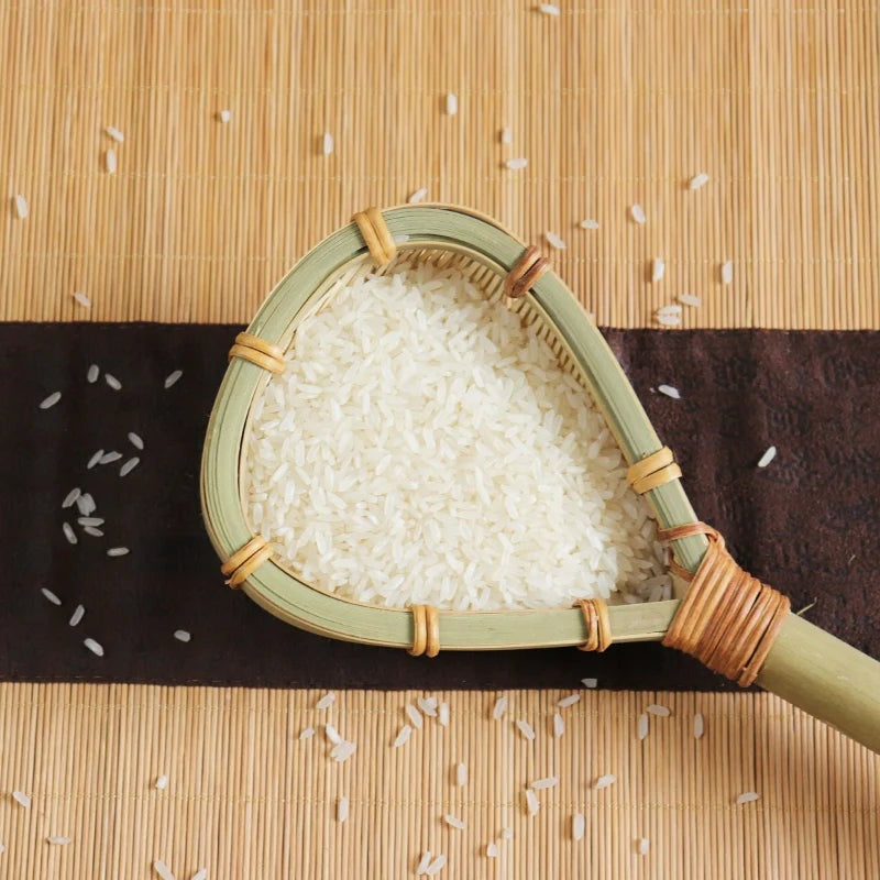 Close-up of a woven bamboo strainer full of white rice on a bamboo mat, Serein Home