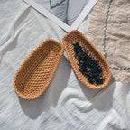 Side view of oval handwoven rattan tray showing weave depth and warm natural color