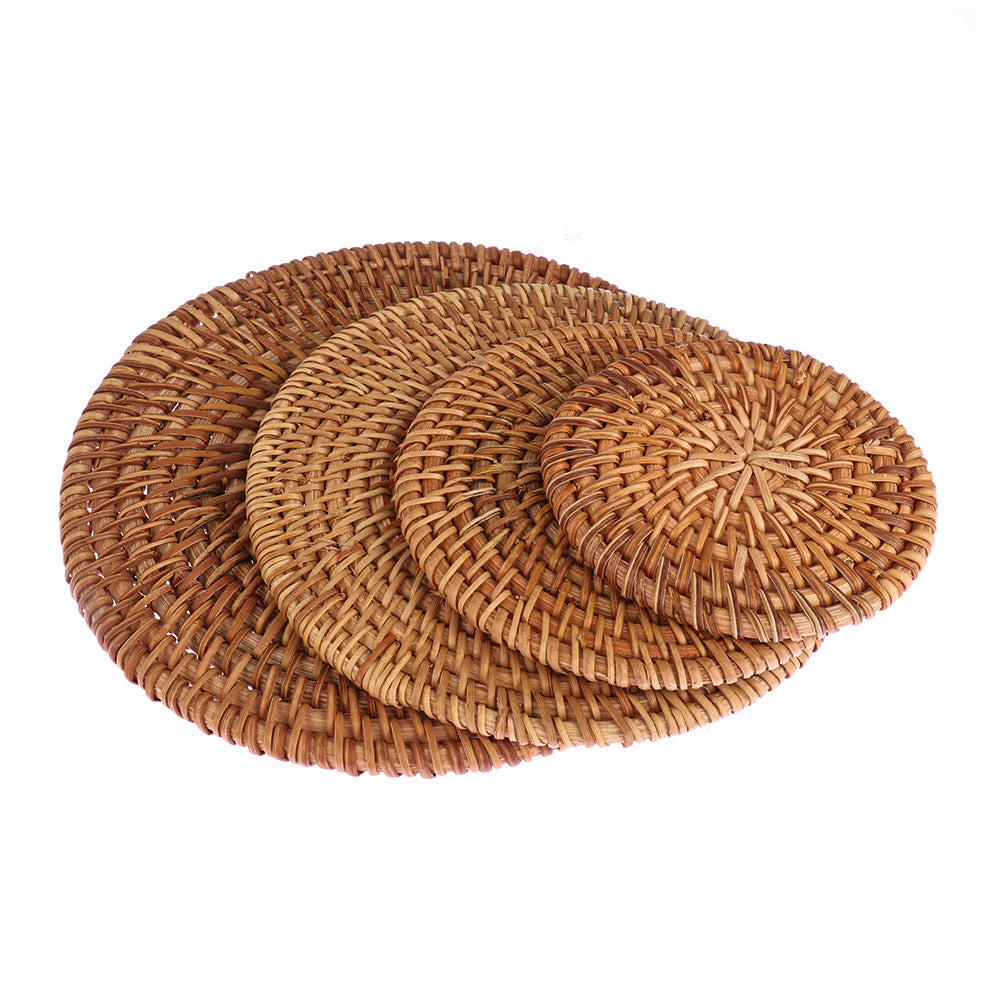 Four natural rattan coasters laid flat showing graduated sizes side by side