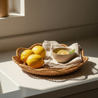 Natural rattan scalloped tray holding fruit on warm wooden kitchen counter