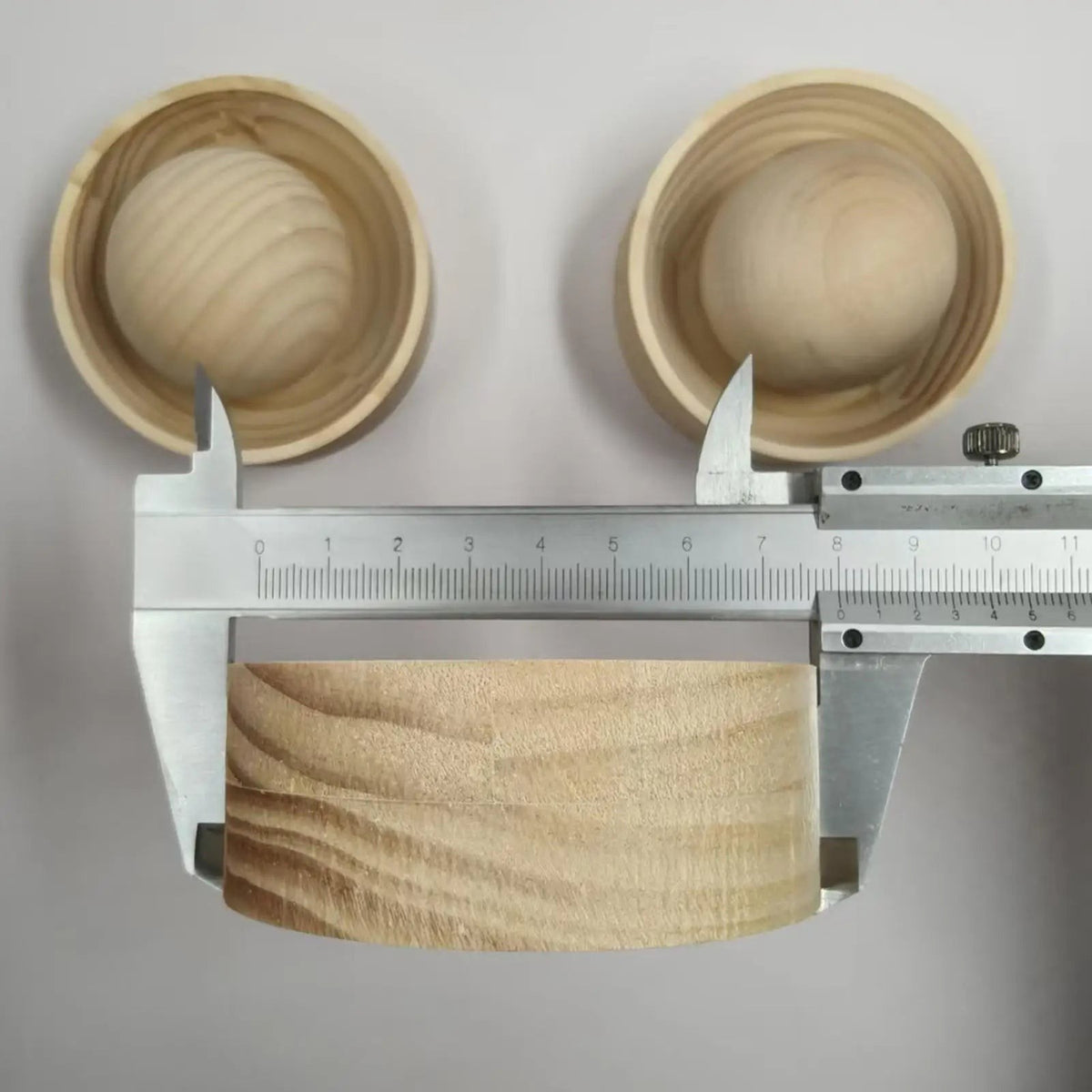 Side view of the wooden dumpling press cup measured with a steel caliper, showing wood grain, Serein Home