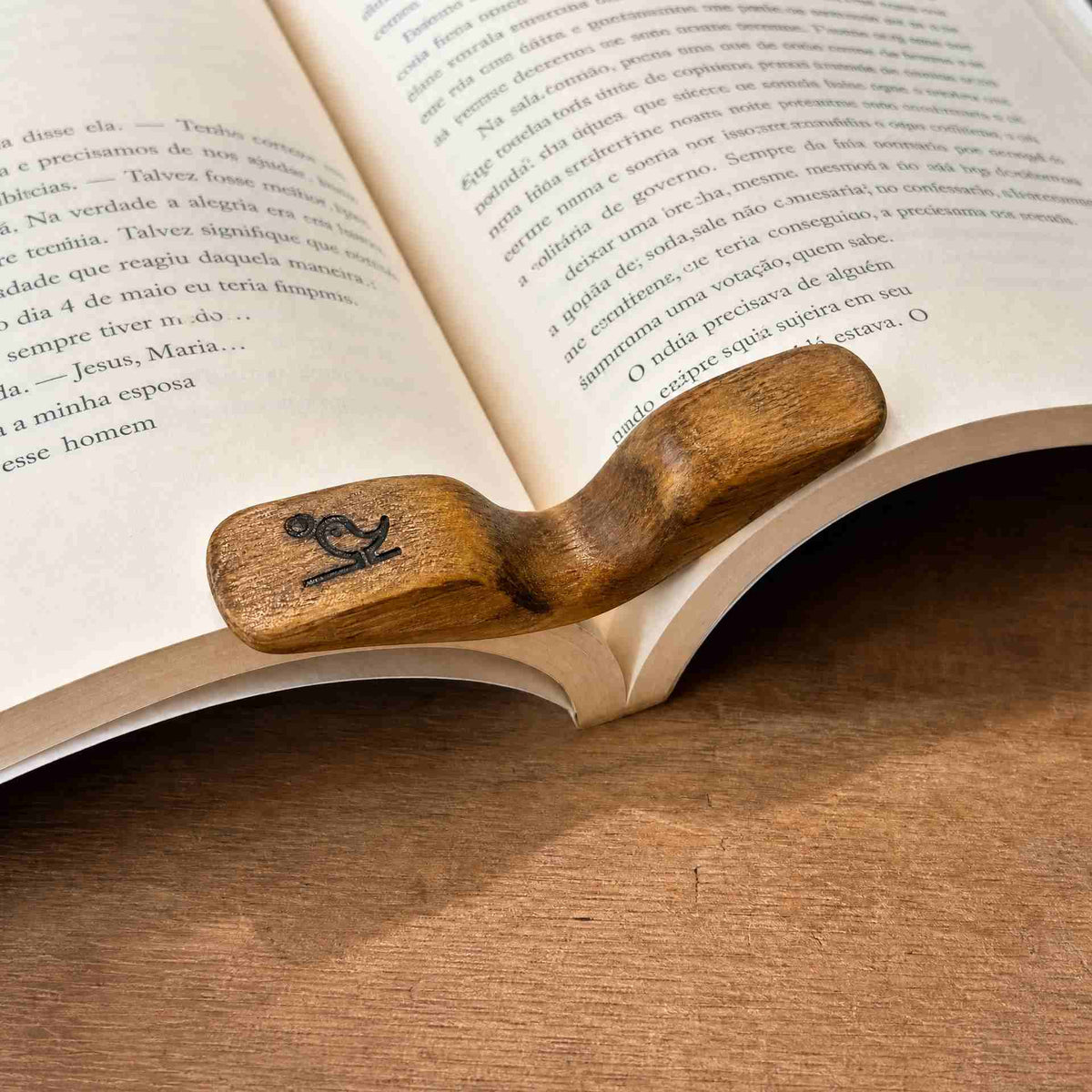 Wooden thumb book page holder resting on an open book on a linen table runner- Serein Home