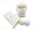 Two wool dryer balls beside the 6 pack canvas storage bag, one bag open to show the wool inside-Serein Home