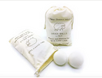 Two wool dryer balls beside the 6 pack canvas storage bag, one bag open to show the wool inside-Serein Home