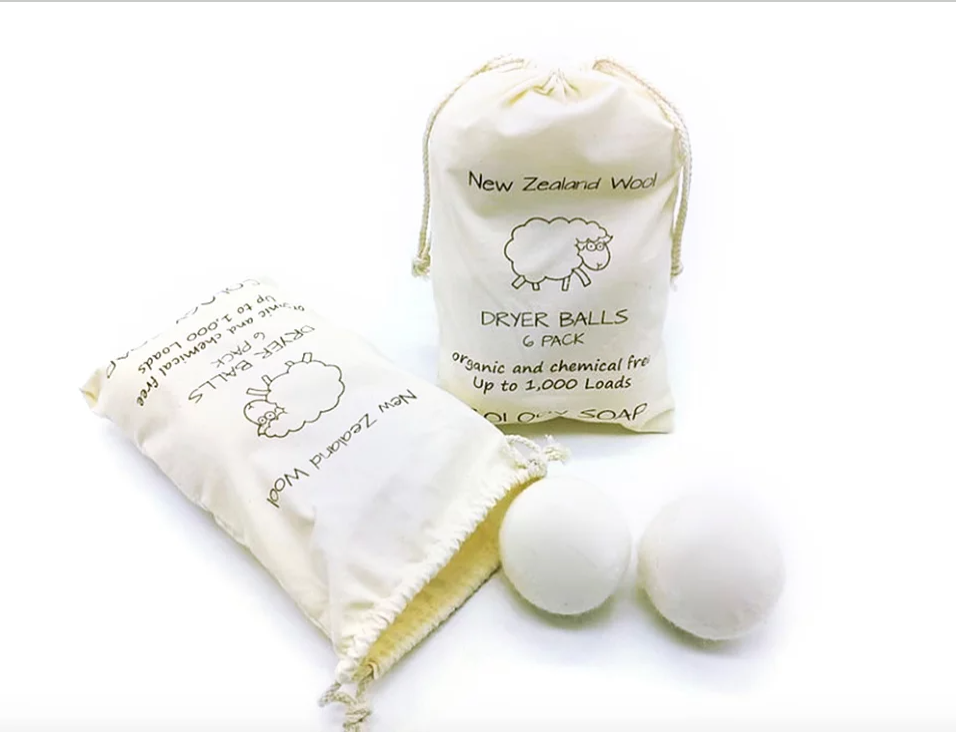 Two wool dryer balls beside the 6 pack canvas storage bag, one bag open to show the wool inside-Serein Home