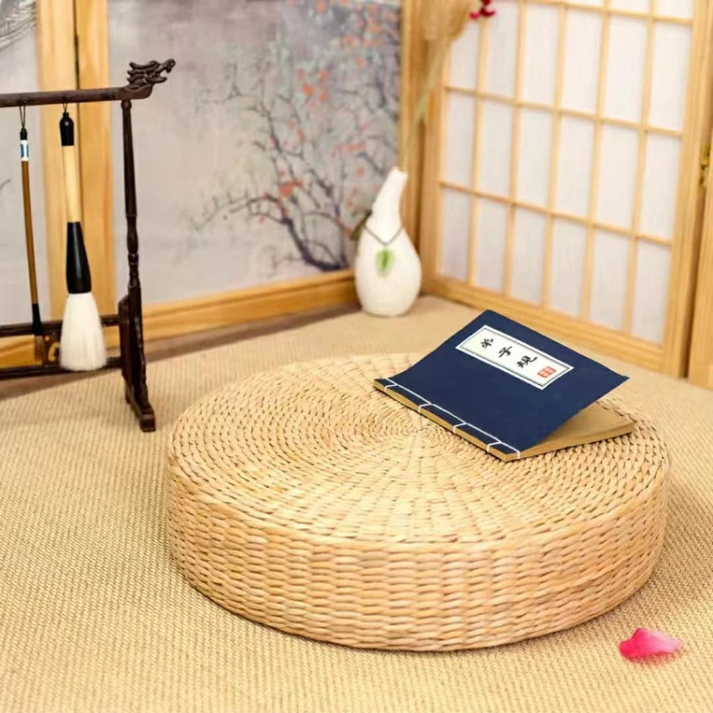 Round woven straw floor cushion in a tea room with shoji screen and a calligraphy book on top, Serein Home