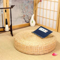 Round woven straw floor cushion in a tea room with shoji screen and a calligraphy book on top, Serein Home