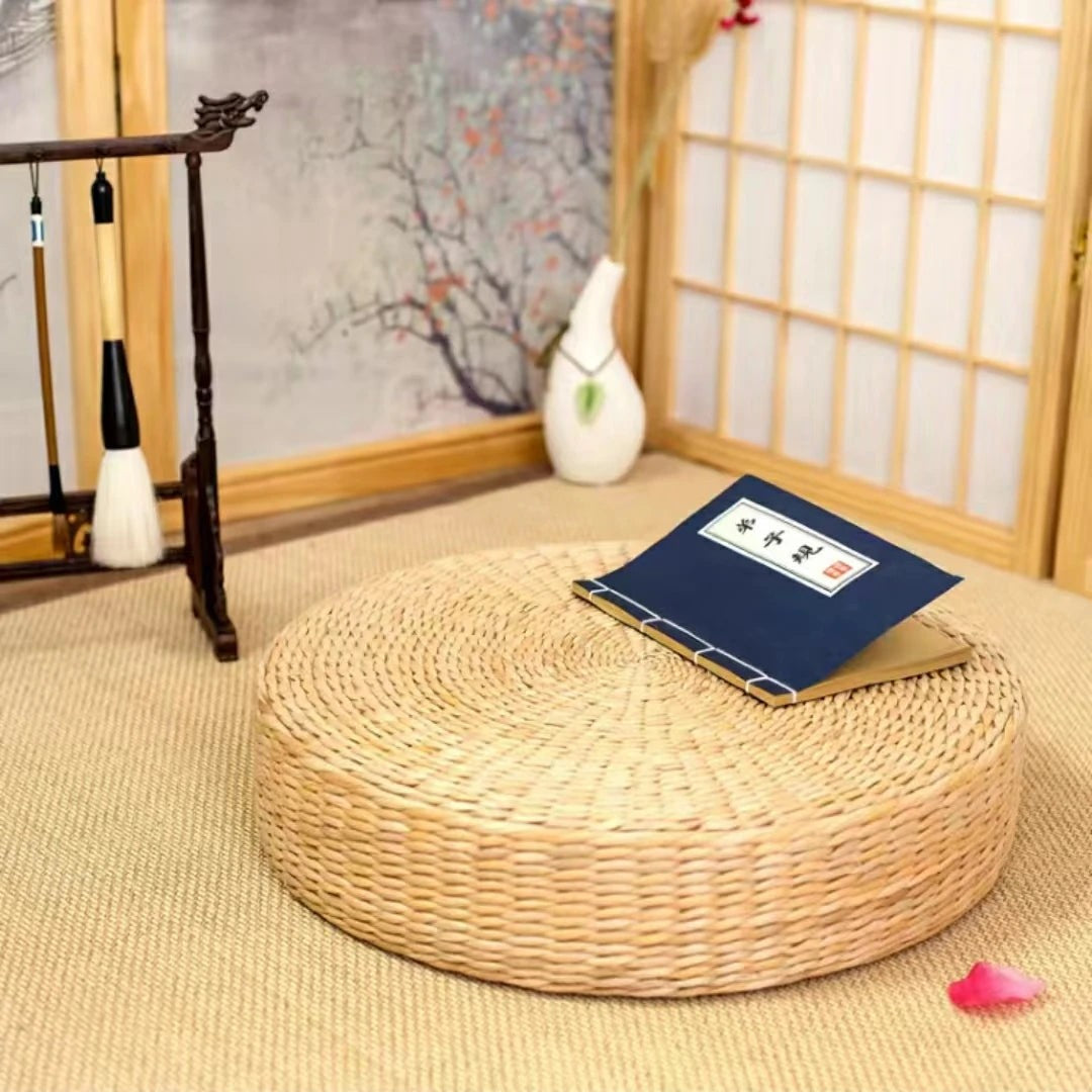 Round woven straw floor cushion in a tea room with shoji screen and a calligraphy book on top, Serein Home