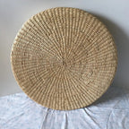 Straw floor cushion standing on its edge, showing the spiral weave, Serein Home