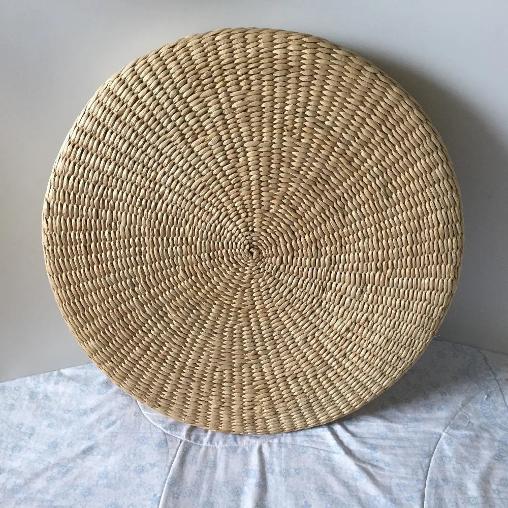Straw floor cushion standing on its edge, showing the spiral weave, Serein Home